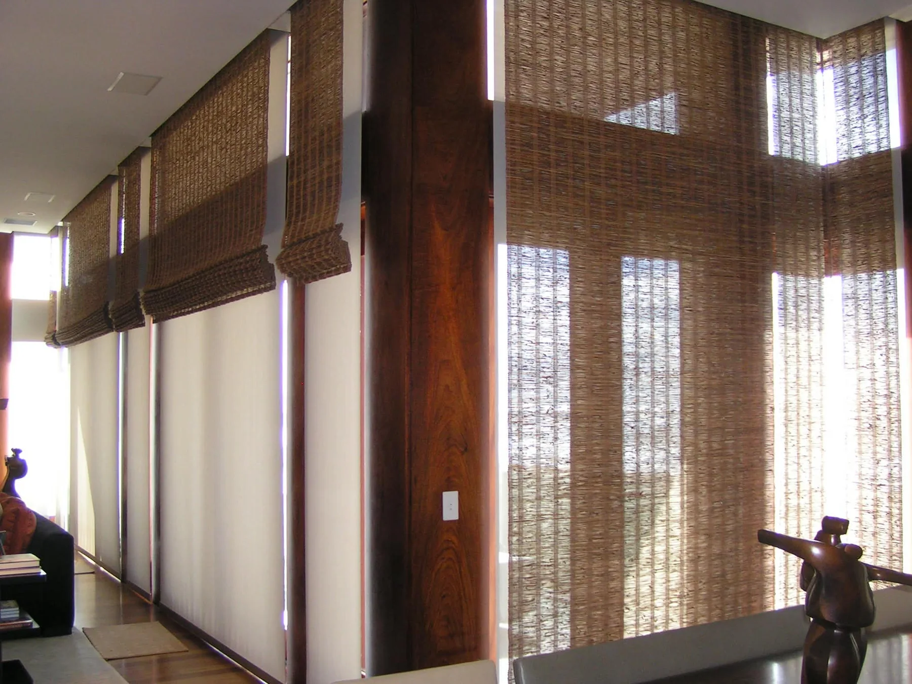 Woven shades installed across a warm wood interior